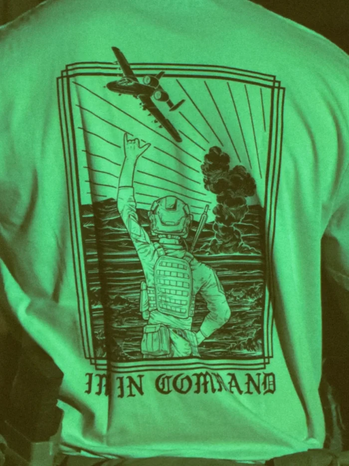 the trace apparel collection featuring a fst jtac guy standing in front of a firing plane