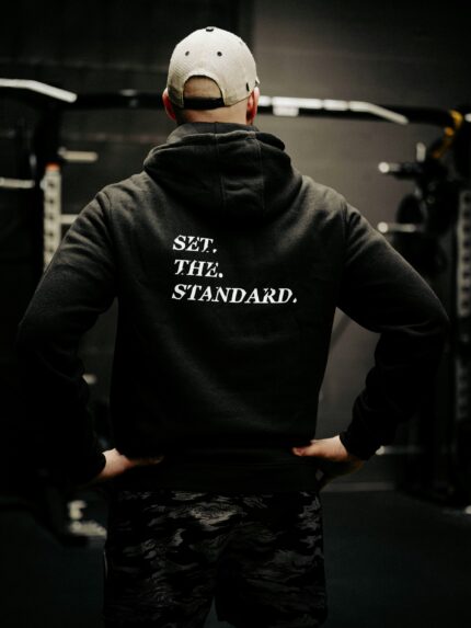 Black hoodie from The Trace featuring Set the Standard design symbolizing the pursuit of the highest performance