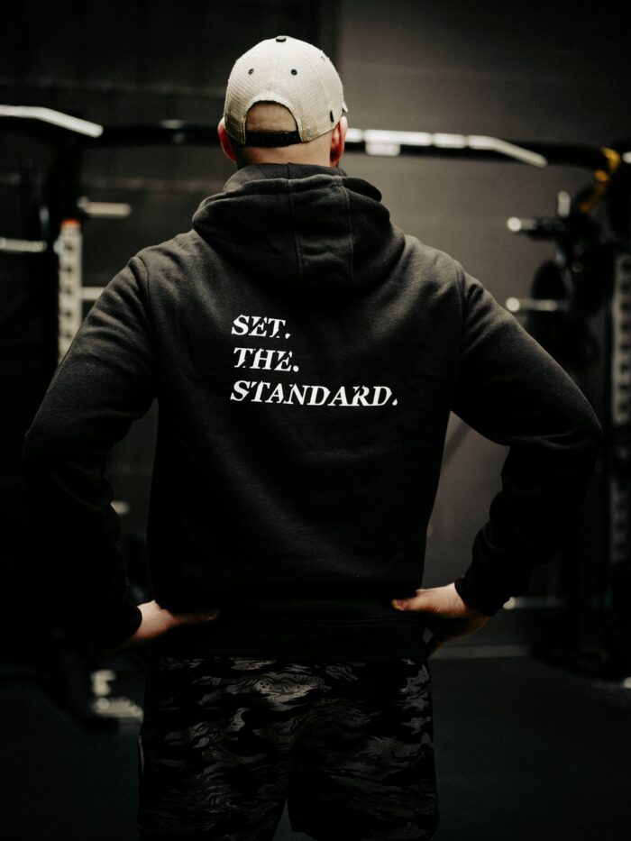 Black hoodie from The Trace featuring Set the Standard design symbolizing the pursuit of the highest performance