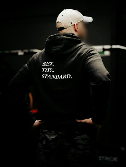Black hoodie from The Trace featuring Set the Standard design symbolizing the pursuit of the highest performance