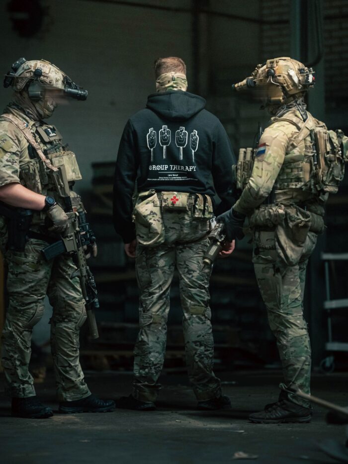 Black hoodie from The Trace featuring Group Therapy design with four targets marked by tight bullet hole groupings