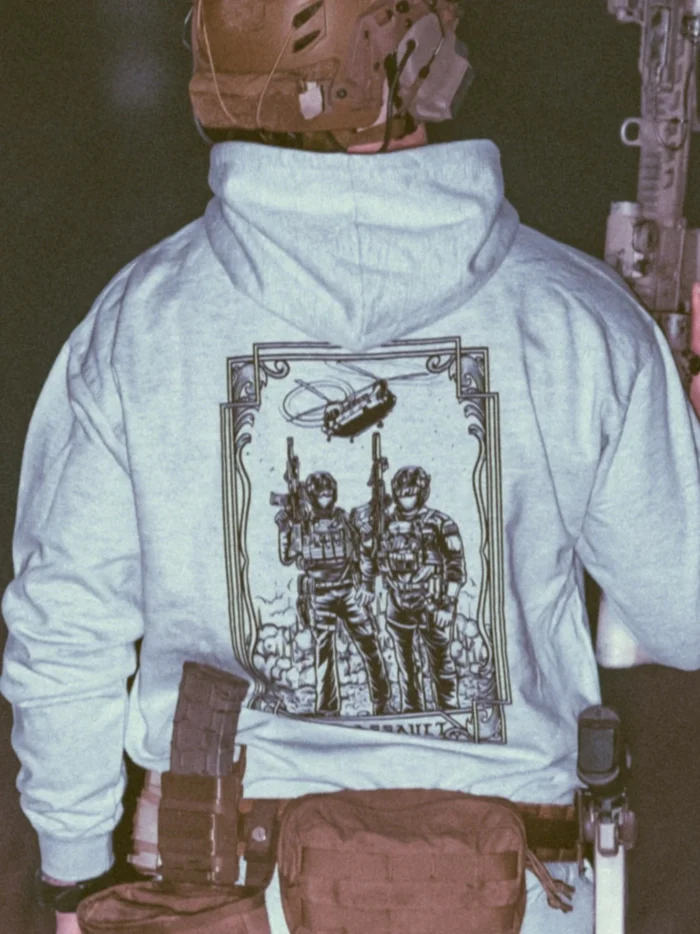 the trace apparel collection featuring 2 air assault operators standing in front of a chinook