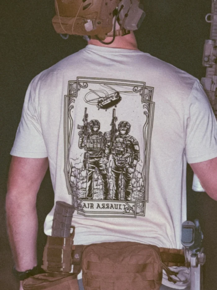 the trace apparel collection featuring 2 air assault operators standing in front of a chinook