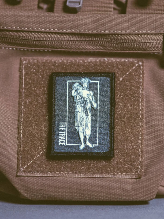 the trace apparel collection patch featuring a woman holding a anti tank weapon