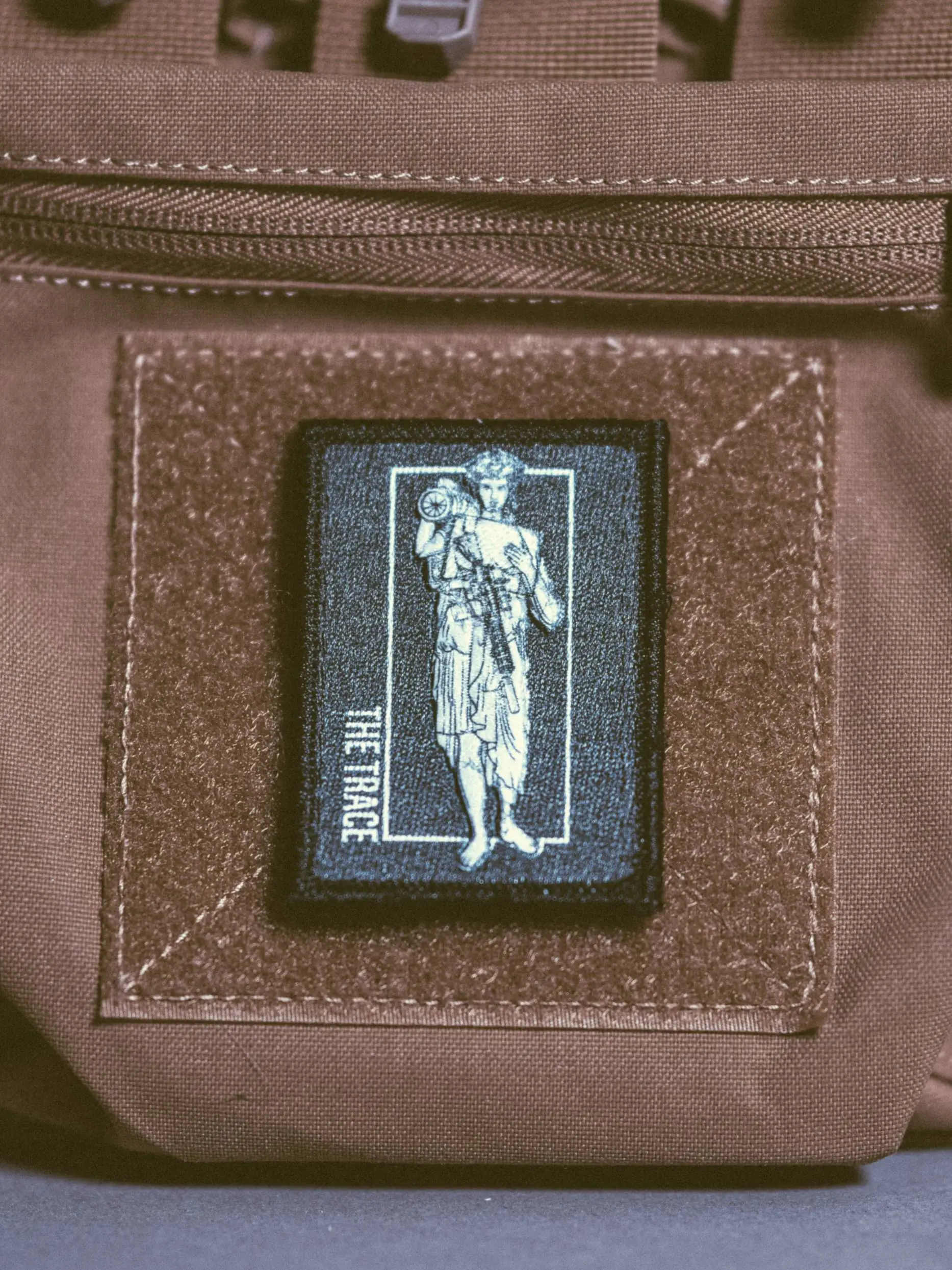 the trace apparel collection patch featuring a woman holding a anti tank weapon