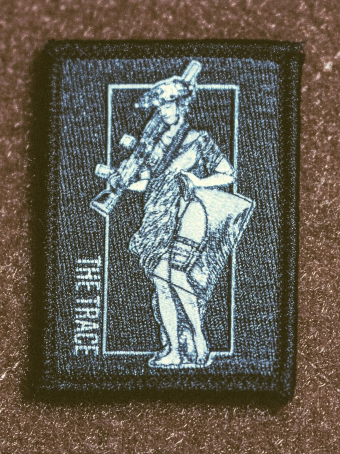 the trace apparel collection patch featuring a woman holding a machine gun