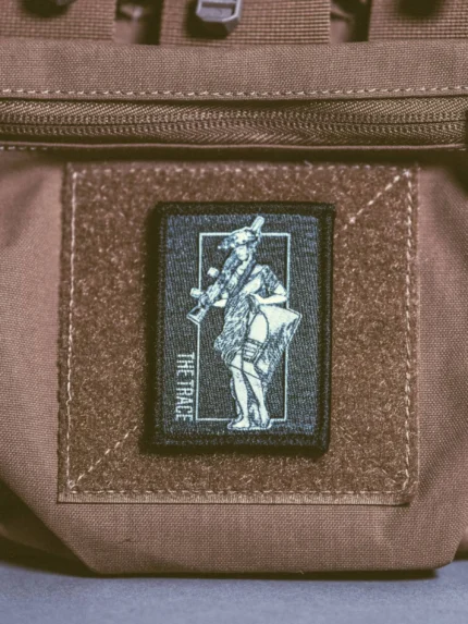 the trace apparel collection patch featuring a woman holding a machine gun