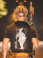 black shirt from The Trace featuring a girl carrying a machinegun