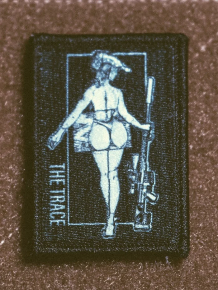 the trace apparel collection patch featuring a woman holding a sniper