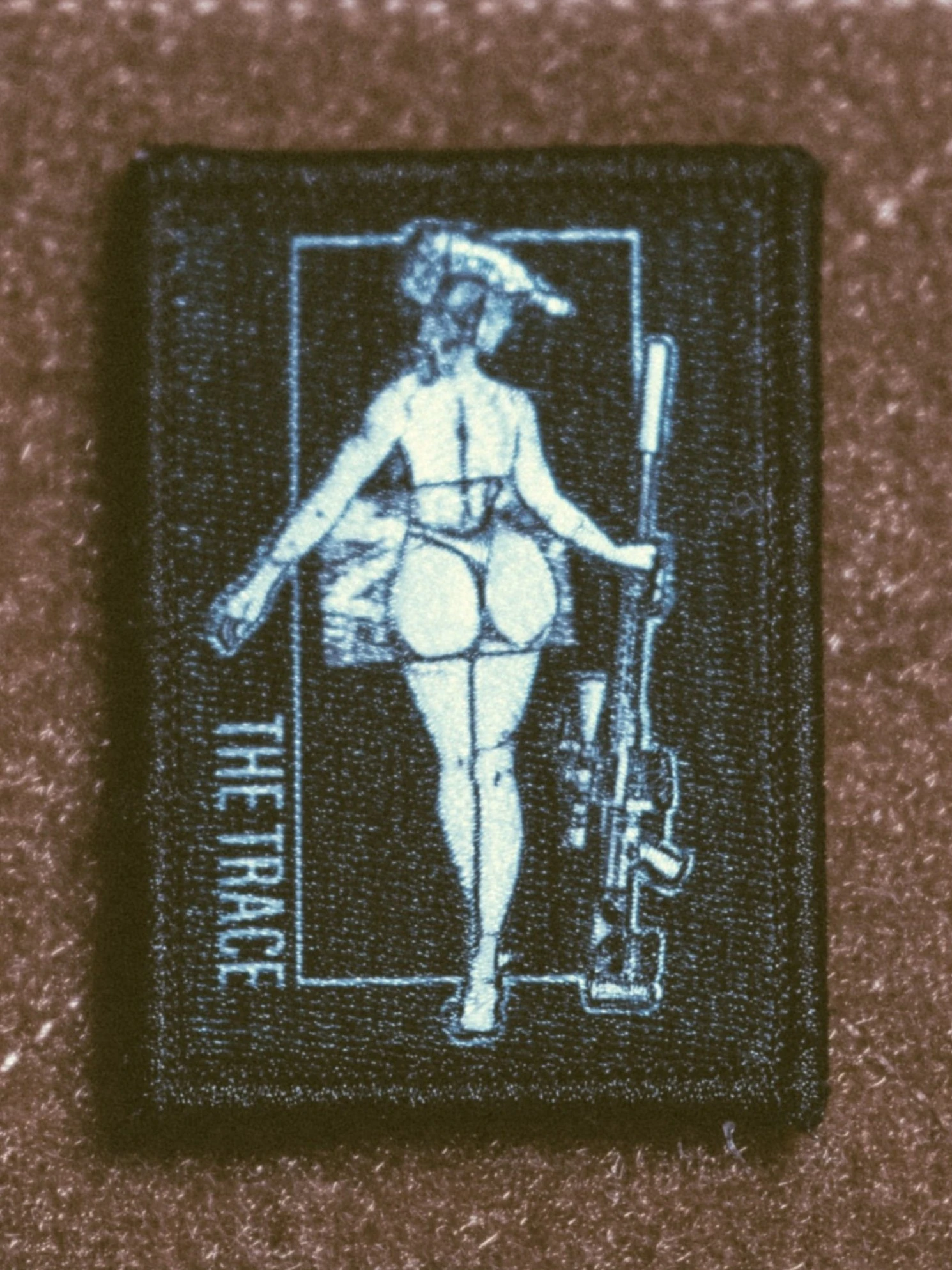 the trace apparel collection patch featuring a woman holding a sniper