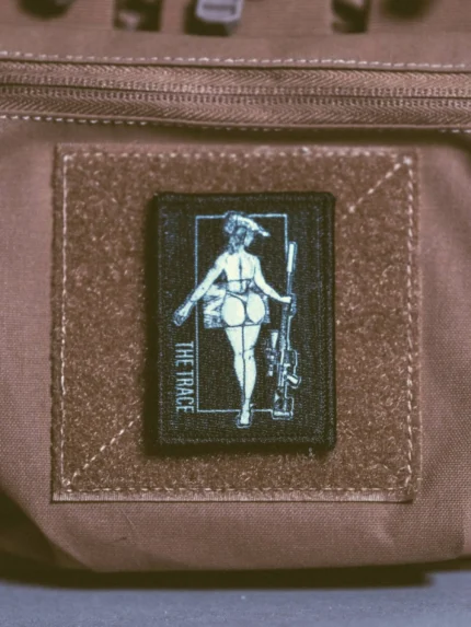 the trace apparel collection patch featuring a woman holding a sniper