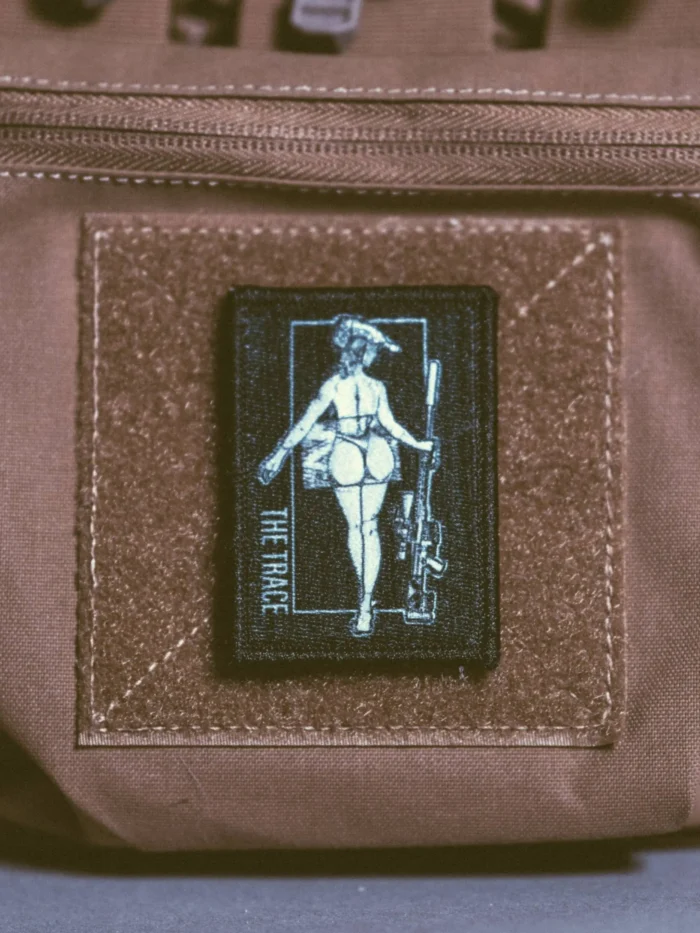the trace apparel collection patch featuring a woman holding a sniper