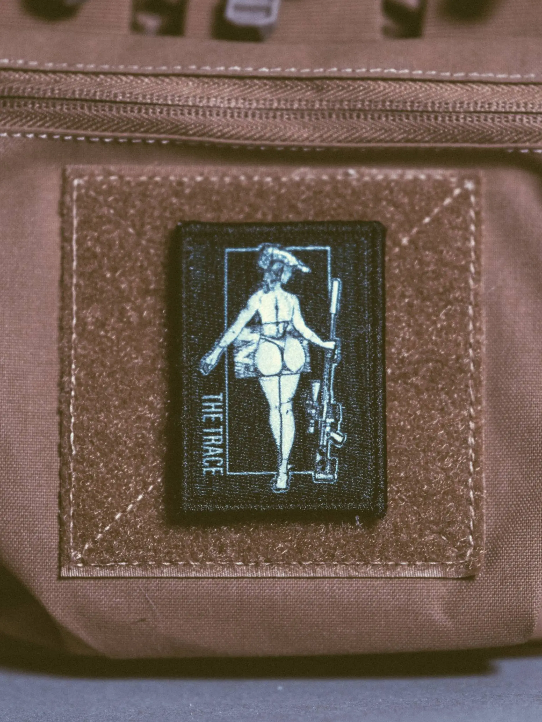 the trace apparel collection patch featuring a woman holding a sniper