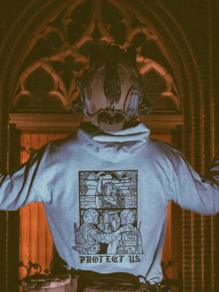 the trace apparel collection featuring a military and a police guy standing in front of a tinted window that displays saint michael the protector